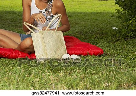 Stock Image - Young woman holding a bag. Fotosearch