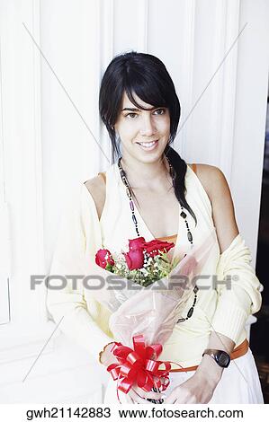 Young woman holding a bouquet of flowers and smiling View Large Photo Image Stock Image - Young woman holding a bouquet of flowers and smiling. Fotosearch
