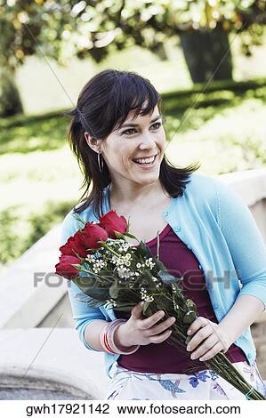 Young woman holding a bunch of roses View Large Photo Image Stock Image - Young woman holding a bunch of roses. Fotosearch