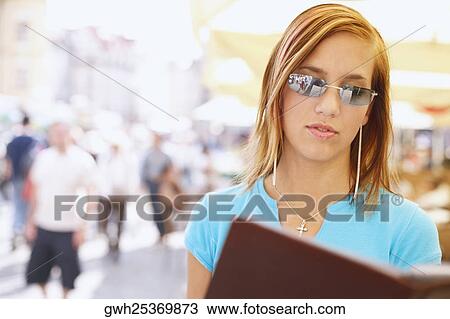 Stock Image - Young woman holding a menu . Fotosearch