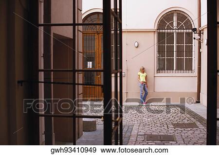 Stock Photo - Young woman leaning against a wall . Fotosearch