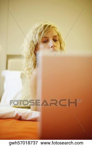 Stock Photo - Young woman looking down at a laptop. Fotosearch