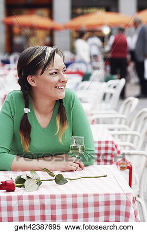 Stock Photography - Young woman sitting at a sidewalk cafe . Fotosearch