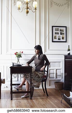 Young woman sitting on a chair View Large Photo Image Stock Image - Young woman sitting on a chair. Fotosearch