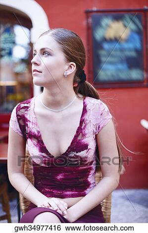 Stock Photograph - Young woman sitting on a chair. Fotosearch