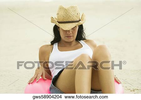 Picture - Young woman sitting on an inflatable ring. Fotosearch