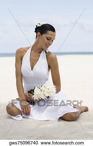 Young woman smiling and sitting on the beach View Large Photo Image Stock Image - Young woman smiling and sitting on the beach. Fotosearch