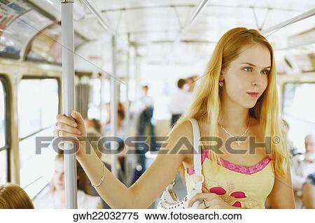 Young woman standing in a train View Large Photo Image Stock Photography - Young woman standing in a train . Fotosearch