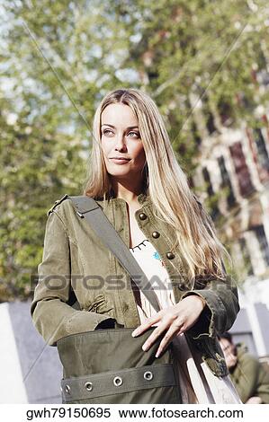 Stock Photography - Young woman standing with a bag . Fotosearch