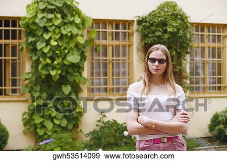 Young woman standing with her arms crossed View Large Photo Image Stock Photo - Young woman standing with her arms crossed . Fotosearch