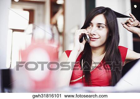 Stock Image - Young woman talking on a mobile phone. Fotosearch