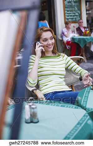 Young woman talking on a mobile phone in a restaurant View Large Photo Image Stock Photo - Young woman talking on a mobile phone in a restaurant . Fotosearch