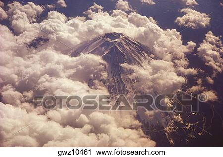 Aerial view of a volcanic mountain surrounded by clouds, Mt Fuji, Honshu, Japan View Large Photo Image Stock Image - Aerial view of a volcanic mountain surrounded by clouds, Mt Fuji, Honshu, Japan. Fotosearch