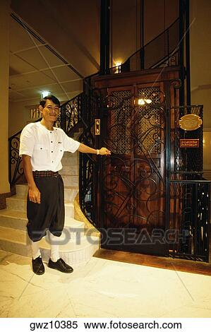 Bellhop standing near an elevator, Grand Hotel D'angkor, Siem Reap, Cambodia View Large Photo Image Stock Photography - Bellhop standing near an elevator, Grand Hotel D'angkor, Siem Reap, Cambodia. Fotosearch