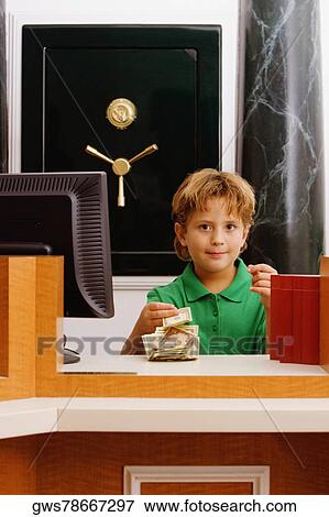 Boy imitating a cashier in a bank and counting currency notes View Large Photo Image Stock Photo - Boy imitating a cashier in a bank and counting currency notes. Fotosearch