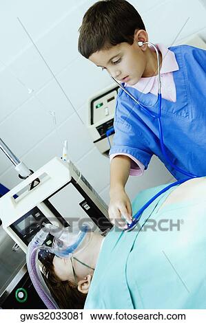 Boy imitating a doctor and examining a patient with a stethoscope View Large Photo Image Stock Image - Boy imitating a doctor and examining a patient with a stethoscope. Fotosearch