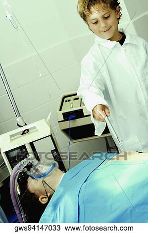 Boy imitating a doctor and standing near a patient View Large Photo Image Stock Image - Boy imitating a doctor and standing near a patient. Fotosearch