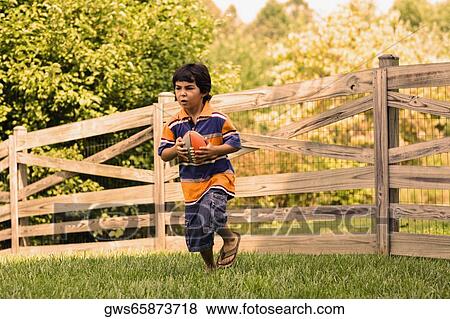Boy playing with a rugby ball View Large Photo Image Stock Photo - Boy playing with a rugby ball. Fotosearch