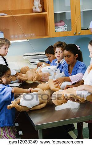 Boys and girls changing the diapers of dolls View Large Photo Image Stock Photo - Boys and girls changing the diapers of dolls. Fotosearch