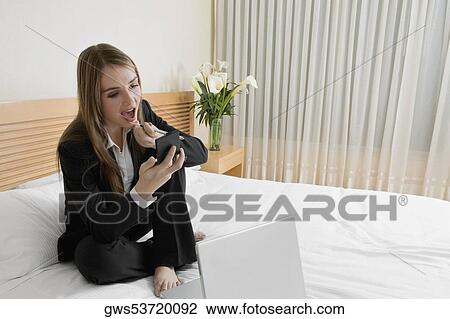 Businesswoman applying lip liner on her lips View Large Photo Image Stock Image - Businesswoman applying lip liner on her lips. Fotosearch