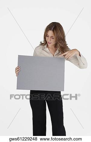 Businesswoman pointing at a blank placard View Large Photo Image Stock Photo - Businesswoman pointing at a blank placard. Fotosearch