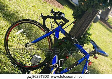 Close-up of a bicycle parked against a wooden post View Large Photo Image Stock Image - Close-up of a bicycle parked against a wooden post. Fotosearch