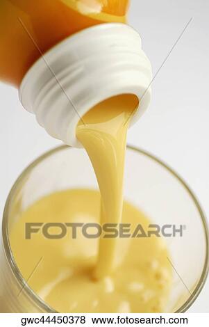Close-up of a bottle of orange juice being poured into a glass View Large Photo Image Stock Photo - Close-up of a bottle of orange juice being poured into a glass. Fotosearch
