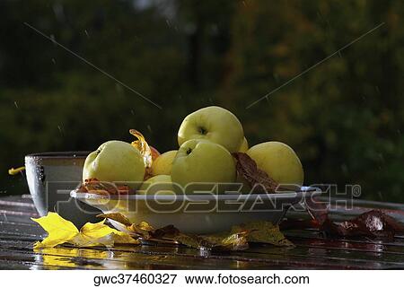 Close-up of a bowl of apples with cups and fallen leaves on the table View Large Photo Image Stock Photo - Close-up of a bowl of apples with cups and fallen leaves on the table. Fotosearch