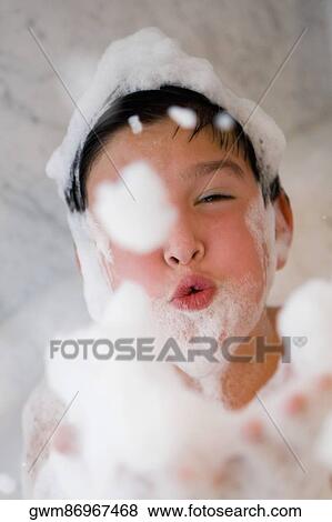 Close-up of a boy blowing soap suds in a bathtub View Large Photo Image Stock Photo - Close-up of a boy blowing soap suds in a bathtub. Fotosearch
