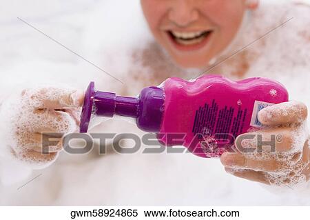 Close-up of a boy holding a soap dispenser in a bathtub View Large Photo Image Stock Photography - Close-up of a boy holding a soap dispenser in a bathtub. Fotosearch