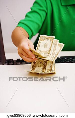 Close-up of a boy holding currency notes View Large Photo Image Stock Photograph - Close-up of a boy holding currency notes. Fotosearch