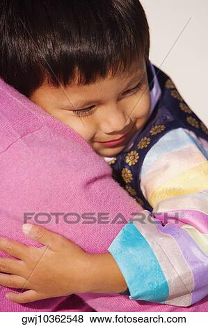 Close-up of a boy hugging his mother View Large Photo Image Stock Photo - Close-up of a boy hugging his mother. Fotosearch