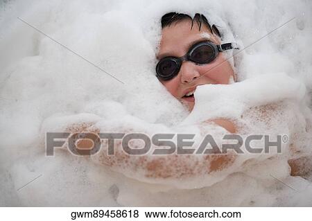 Stock Photo - Close-up of a boy in a bubble bath. Fotosearch