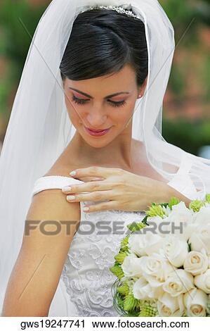 Close-up of a bride holding a bouquet of flowers and smiling View Large Photo Image Stock Image - Close-up of a bride holding a bouquet of flowers and smiling. Fotosearch