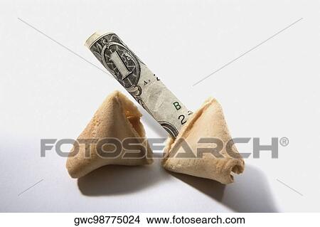 Picture - Close-up of a broken fortune cookie with one dollar bill. Fotosearch