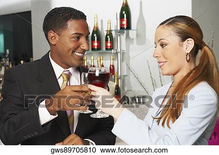 Close-up of a businessman and a businesswoman toasting with wine glasses View Large Photo Image Stock Image - Close-up of a businessman and a businesswoman toasting with wine glasses. Fotosearch