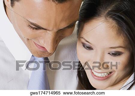 Close-up of a businessman and a businesswoman looking down View Large Photo Image Stock Photography - Close-up of a businessman and a businesswoman looking down. Fotosearch