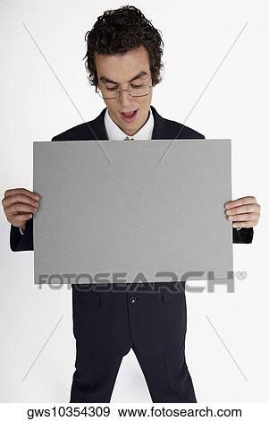 Close-up of a businessman holding a blank placard View Large Photo Image Stock Photo - Close-up of a businessman holding a blank placard. Fotosearch