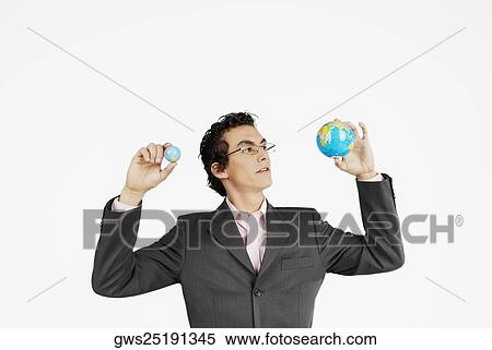 Close-up of a businessman holding globes View Large Photo Image Stock Photography - Close-up of a businessman holding globes. Fotosearch