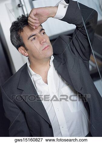 Close-up of a businessman leaning against a glass door with his hand on his forehead View Large Photo Image Stock Photo - Close-up of a businessman leaning against a glass door with his hand on his forehead. Fotosearch