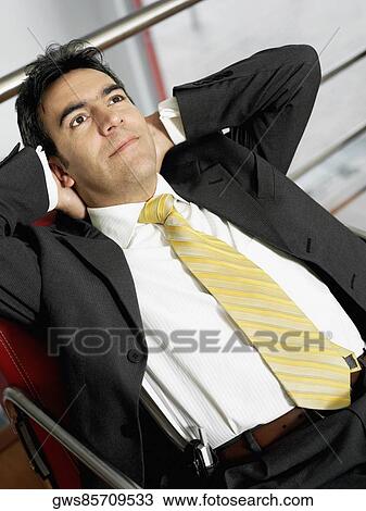 Close-up of a businessman sitting in an armchair with his hands behind his head View Large Photo Image Stock Image - Close-up of a businessman sitting in an armchair with his hands behind his head. Fotosearch