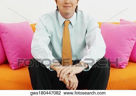 Stock Image - Close-up of a businessman sitting on a couch. Fotosearch