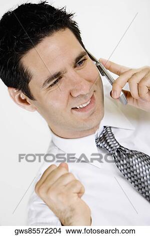 Close-up of a businessman talking on a mobile phone and smiling View Large Photo Image Picture - Close-up of a businessman talking on a mobile phone and smiling. Fotosearch