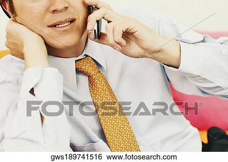 Close-up of a businessman talking on a mobile phone View Large Photo Image Stock Photograph - Close-up of a businessman talking on a mobile phone. Fotosearch
