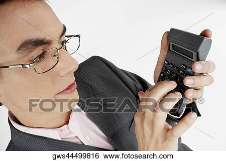 Close-up of a businessman using a calculator View Large Photo Image Stock Photograph - Close-up of a businessman using a calculator. Fotosearch