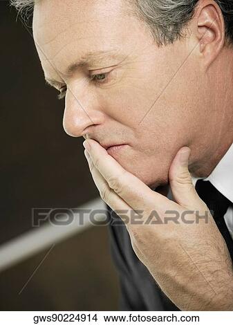 Close-up of a businessman with his hand over his mouth View Large Photo Image Picture - Close-up of a businessman with his hand over his mouth. Fotosearch