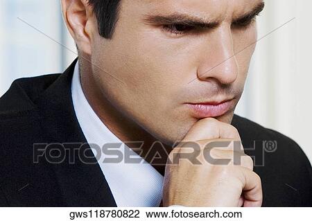 Stock Image - Close-up of a businessman with his hand on his chin. Fotosearch