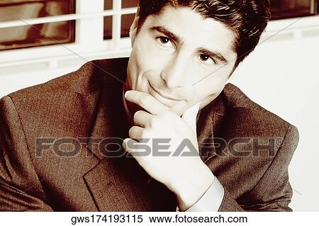 Stock Photography - Close-up of a businessman with his hand on his chin. Fotosearch
