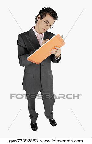 Stock Image - Close-up of a businessman writing on a clip board. Fotosearch