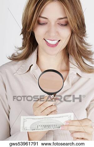 Close-up of a businesswoman examining a dollar bill with a magnifying glass and smiling View Large Photo Image Stock Image - Close-up of a businesswoman examining a dollar bill with a magnifying glass and smiling. Fotosearch